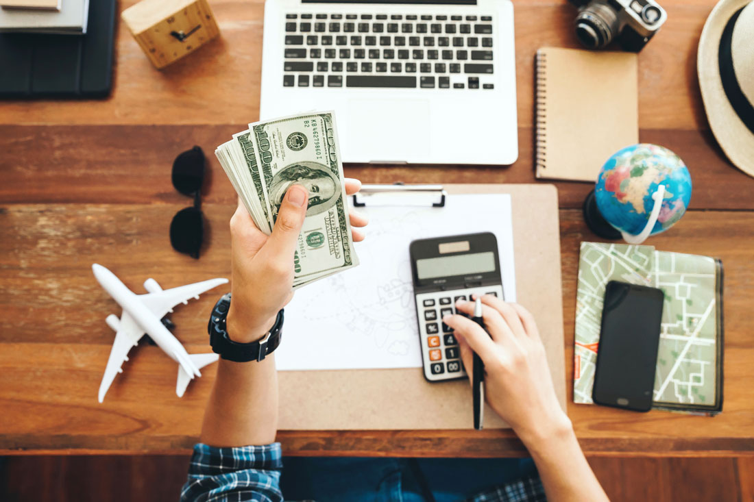 mesa de escritorio con todo lo necesario para preparar un presupuesto para un viaje sin billete de vuelta
