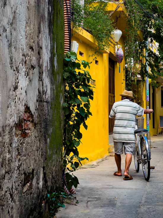 Señor vietnamita paseando en bici por las coloridas calles que ver en Hoi An