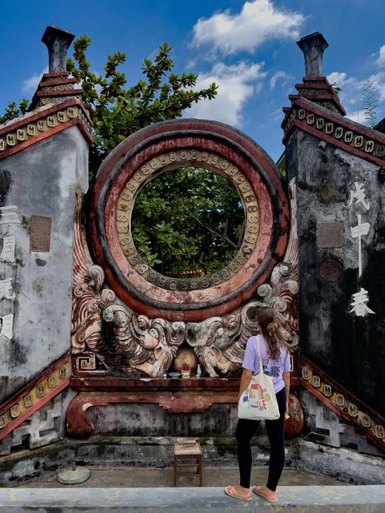 Inma en la puerta central del Templo de Ba Mu, una de las estampas más icónicas que ver en Hoi An