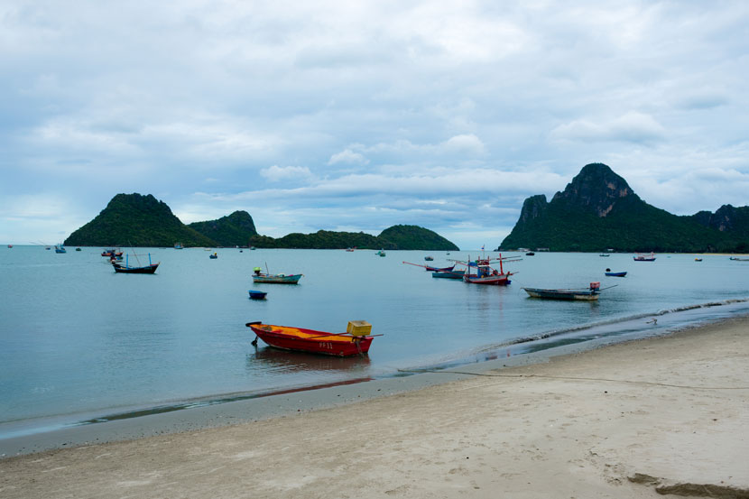 Barquitas, playa y montañas al fondo, un recorrido por el paseo marítimo de Prachuap