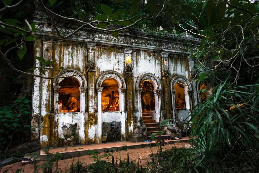 Uno de las salas de oración de Wat Phra Lat, con representaciones de buda y una luz tenue anaranjada que les da un toque de misticismo