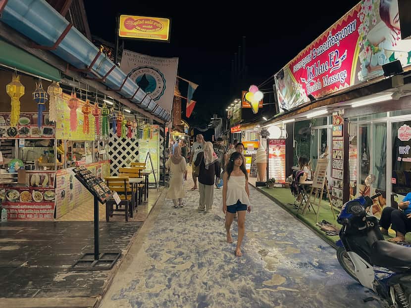 La Walking Street de la isla por la noche, repleta de negocios y opciones donde comer en Koh Lipe